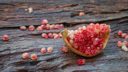 Beautiful pomegranate with sliced and seeds on old dark brown wooden for a background. Close up.