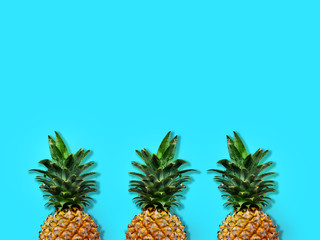 Flat lay pineapples on blue background. Ananas isolated on soft blue surface. Pineapple with blank copy space for message.