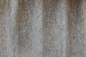 Roof of a country house, covered with gray slate, close-up. Old roof covered with slate. Green moss grows between slate waves. Texture of old roof, slate background