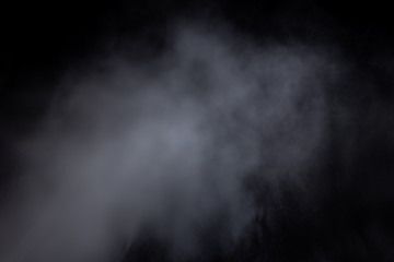Light blue clouds of smoke vapor isolated on a black background. Gas explodes, whirls in space. abstraction