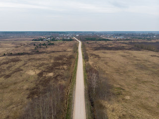 Areal view of old countryside road near agriculture fields.
