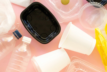 Various plastic waste on a pink background