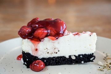 Slice of plain cheesecake with strawberry sauce on white plate.