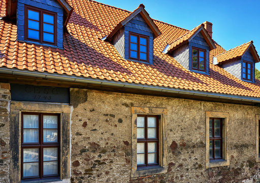 Renovated tiled roof with dormer windows on old brickwork.