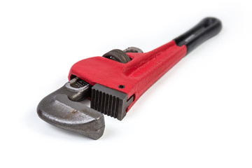 Modern pipe wrench on a white background, closeup in selective focus
