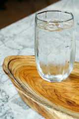 water in  glass on wooden plate.