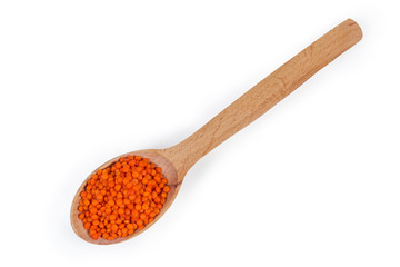 Raw red lentil in wooden spoon on a white background