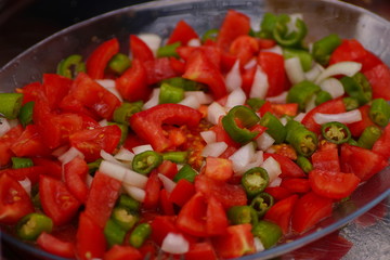 salad with tomato pepper and onions on a metal plate. salad on a metal plate. salad with tomatoes. delicious and healthy salad.