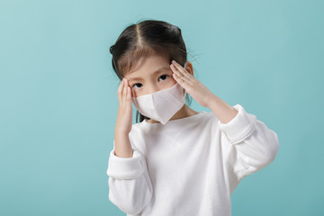 Asian little child girl wearing respirator mask for stop coronavirus outbreak, New virus Covid-19 from Wuhan China concept, Empty space isolated on blue background