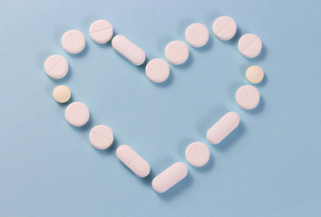 Flat layout white heart shaped pills isolated on blue background