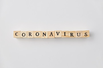 quarantine, epidemic and safety concept - coronavirus word on wooden toy blocks on white background