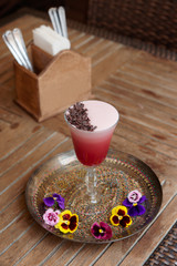 Red frothy cocktail with chocolate on pub table