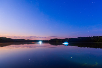 Beautiful night lake landscape. Calm lake like a mirror