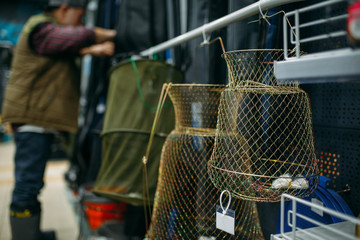 Male angler choosing net in fishing shop