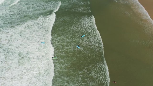 Pan up shot off surfers and the beatch