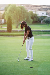 Woman playing golf on beautiful golf course