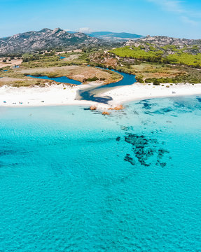 Bird's eye view of a sea landscape with a river mouth and green meadow, Berchida, Sardinia, Italy