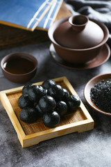 Chinese black sesame ball on bamboo plate with tea