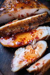 Grilled chicken fillets on wooden cutting board with sauce