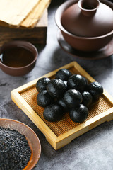 Chinese black sesame ball on bamboo plate with tea