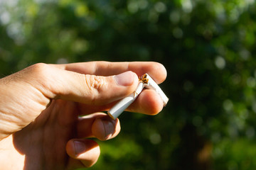 young man breaks a cigarette