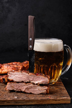 Cutted pork ribs and big glass of beer on cutting board