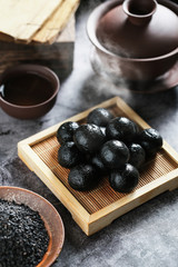 Chinese black sesame ball on bamboo plate with tea