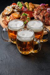 Three glasses of beer and large dish of beer snacks
