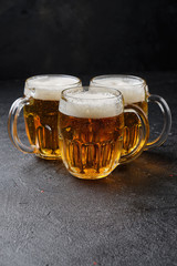 Three glasses of beer on dark