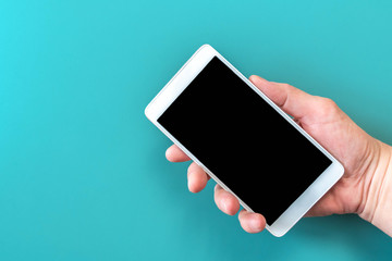 Person hand holding phone on blue isolated background