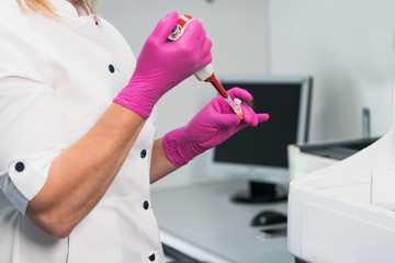 Medical equipment. Blood test.Pipette adding fluid to one of several test tubes .