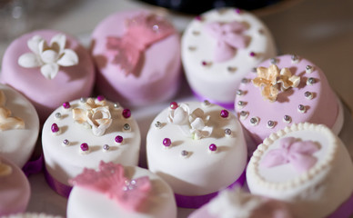 Cakes decorated with pearls and sweet flowers. Wedding treats, delicious decor for the holiday.