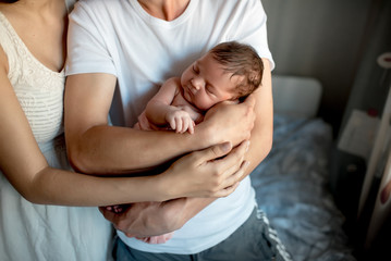 Fototapeta na wymiar Newborn baby with mom and dad at home 