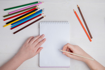 Children's hands draw with crayons