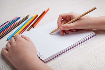 Children's hands draw with crayons