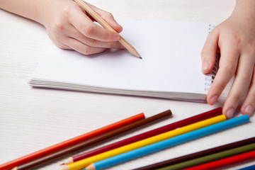 Children's hands draw with crayons