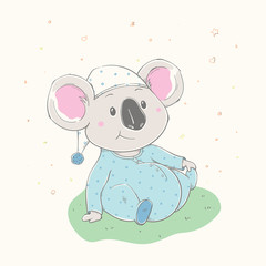 Lovely cute koala is sitting on the grass. Beautiful koala boy dressed in pajamas with hat. - 343420926