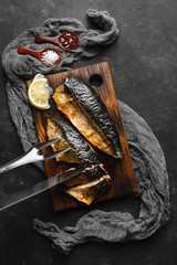 Delicious baked mackerel fillet with paprika, garlic and lemon, on a dark wooden Board with spices...
