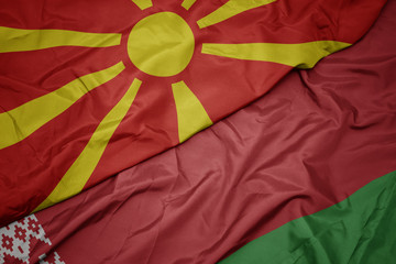 waving colorful flag of belarus and national flag of macedonia.