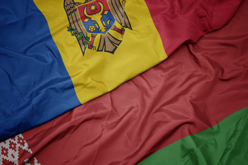 waving colorful flag of belarus and national flag of moldova.