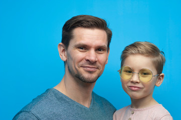 Portrait of positive handsome man and little child wearing stylish eyeglasses