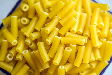 raw italian macaroni pasta inside clear storage container