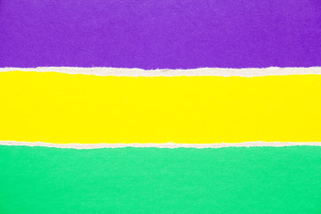 Purple, yellow and green torn sheet of cardboard paper texture background. Copy space for text message.