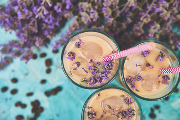 Summer drink iced coffee with lavender in glass and coffee beans on blue background. Good Morning concept. Baeutiful ice coffee.