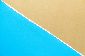 Blue and golden brown torn sheet of cardboard paper with diagonal border texture background. Can be...