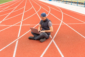 The guy with the laptop sits in the stadium, the programmer in the empty stadium. Working in unusual places