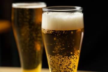 Close-up of goblets with pouring beer