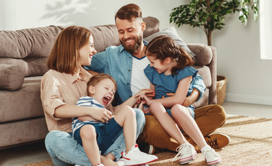 Cheerful parents with kids having fun at home.