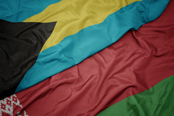 waving colorful flag of belarus and national flag of bahamas.