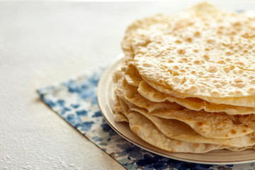 Stack of fresh homemade pita bread on plate. Copy space for text.